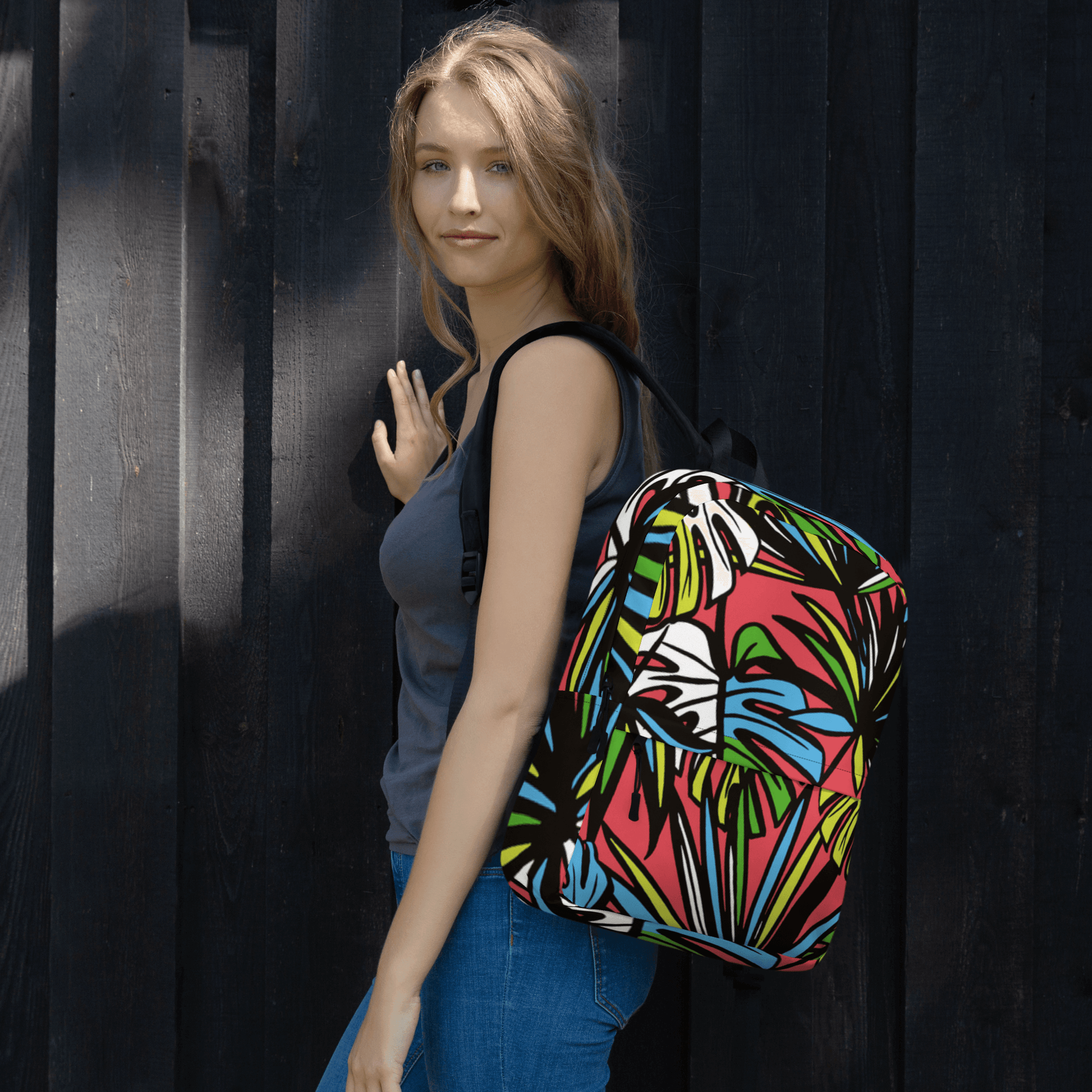 🔵 SELVA 🔵 - Mochila URBAN Unisex 🔵 modelada por mujer con estampado selvático sobre fondo negro.