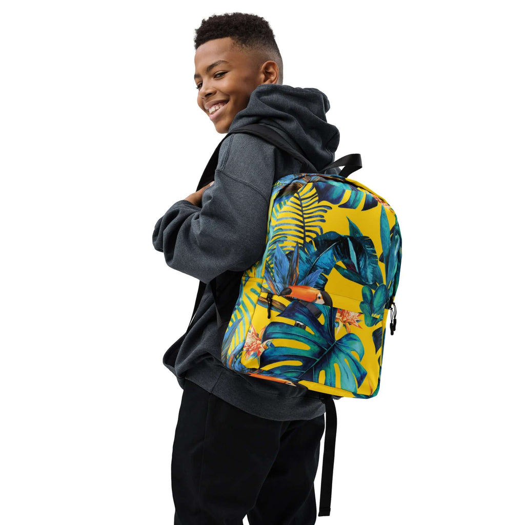 MOCHILA TUKAN URBAN UNISEX con diseño tropical y estilo urbano, llevada por un joven con sudadera.