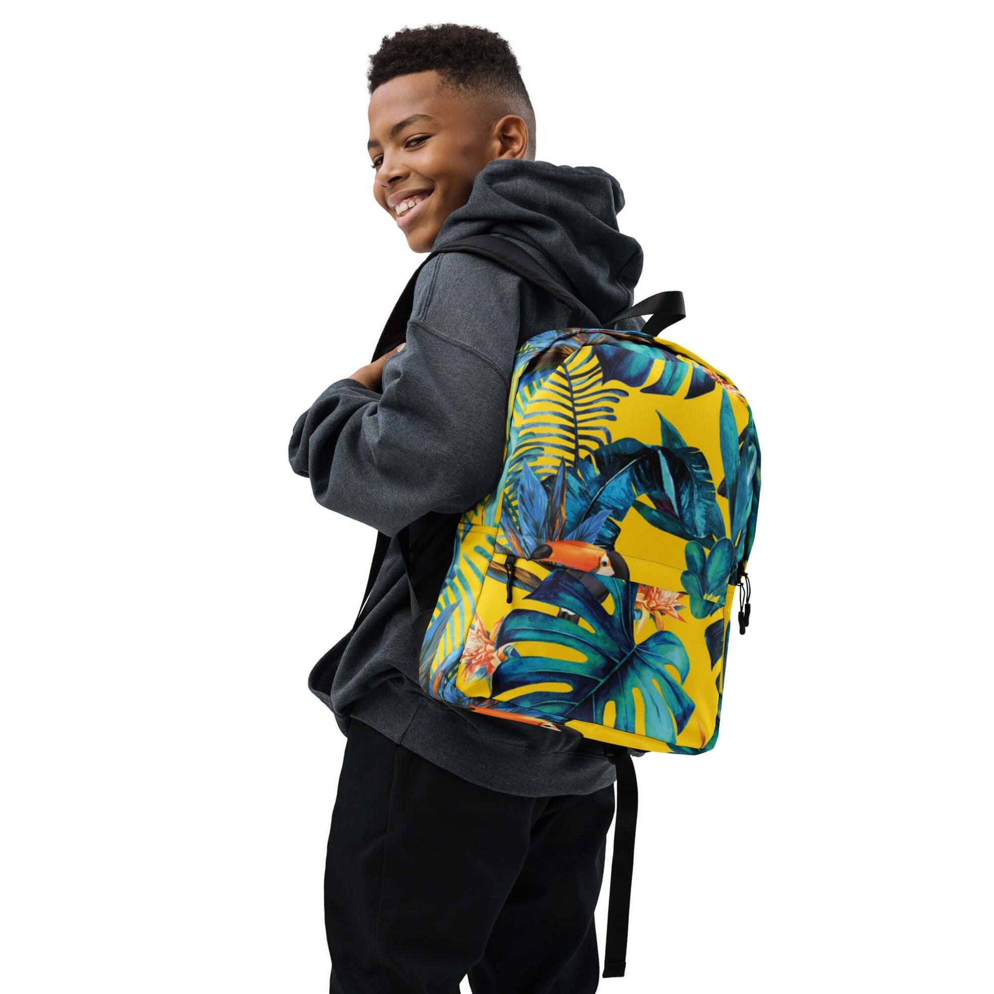 MOCHILA TUKAN URBAN UNISEX con diseño tropical y estilo urbano, llevada por un joven con sudadera.