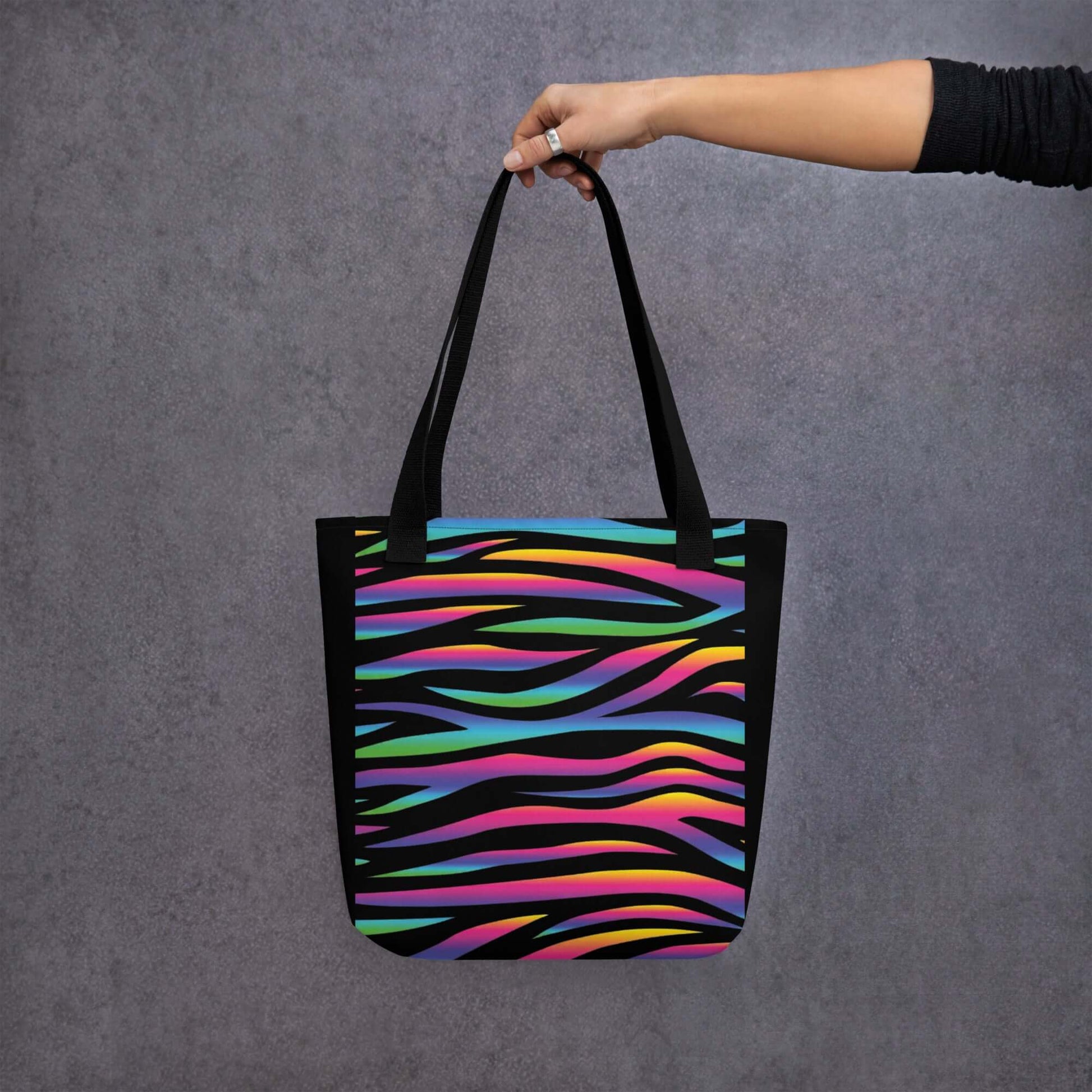 BOLSA CEBRA COLORES en mano, bolsa de tela urbana con diseño vibrante y llamativo en colores brillantes.