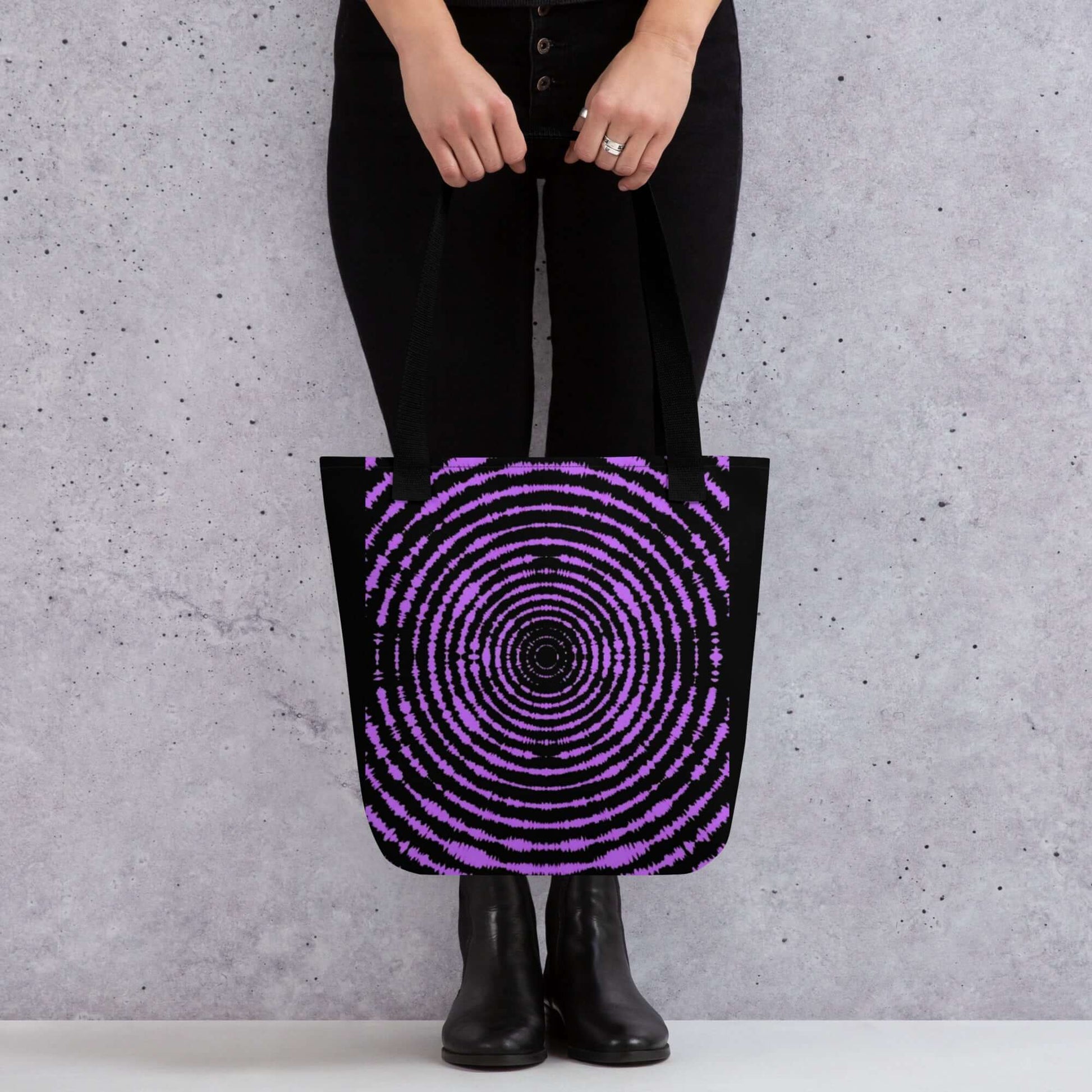 Bolsa de tela ESPIRAL en color negro y púrpura, diseño único urbano en manos de modelo, perfecta para estilo streetwear.