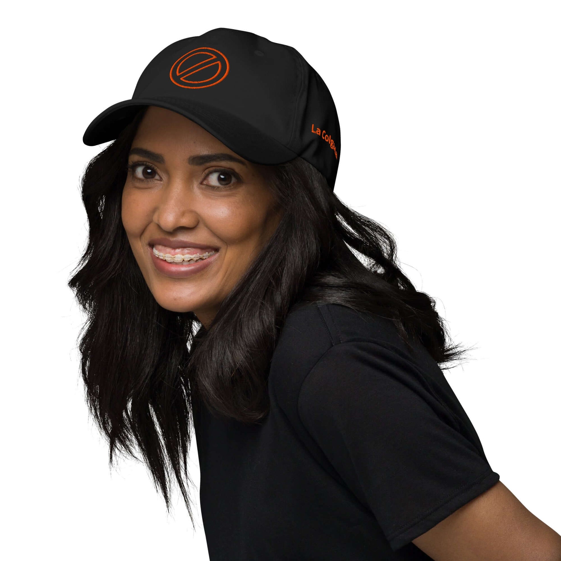GORRA PROHIBIDO - Mujer sonriendo mientras usa una gorra negra bordada de La Colgada, estilo urbano unisex.