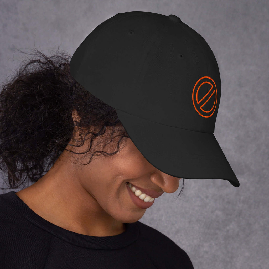 Mujer sonriendo con gorra negra bordada, estilo urbano, diseño moderno.