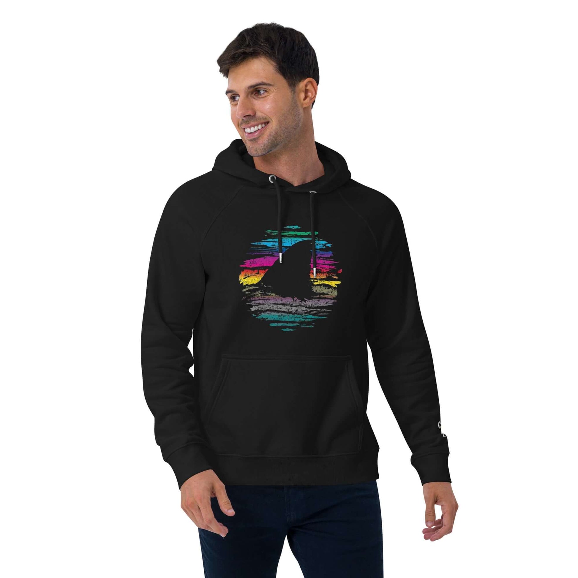 🔵🦈 SUDADERA TIBURÓN - UNISEX 🦈🔵 modelo masculino luciendo sudadera negra con diseño de tiburón sobre fondo colorido.